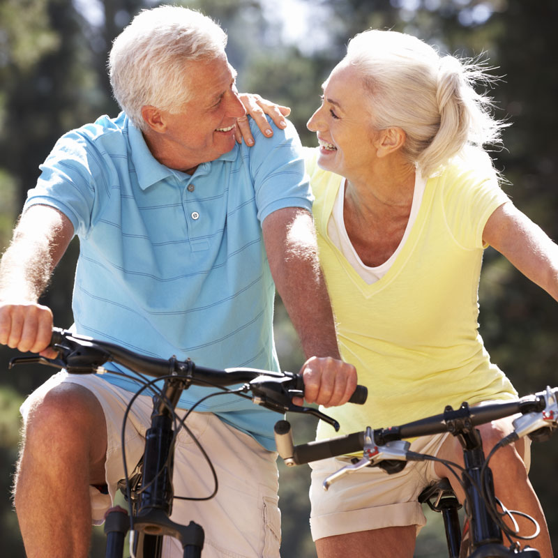 senior couple smiling riding bikes